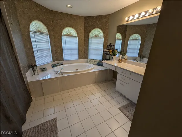 a spacious bathroom with a double vanity sink mirror and bathtub