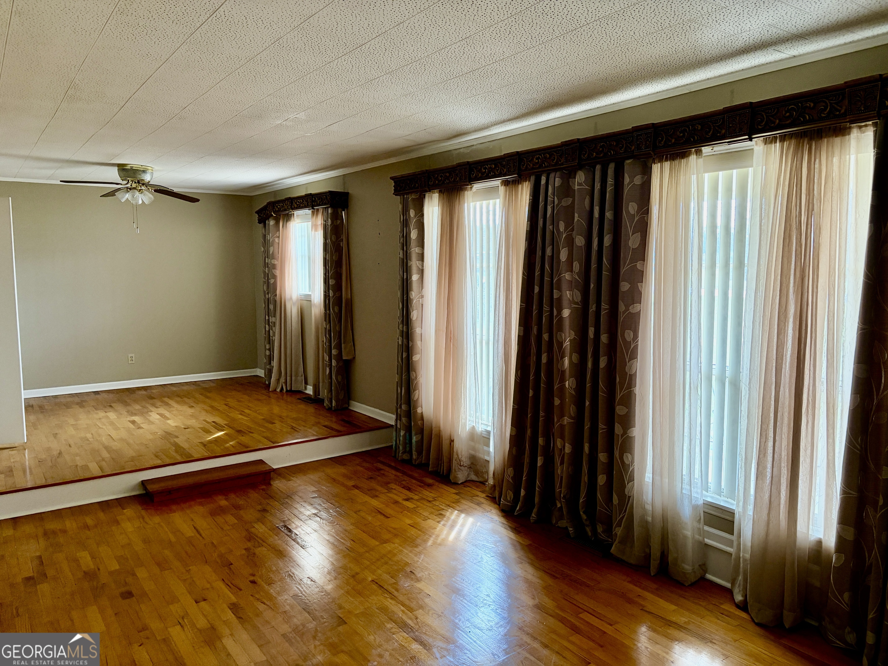 310 McDaniel Station Road Southwest Calhoun, GA 30701 - Photo 8 of 11 an empty room with wooden floor and windows