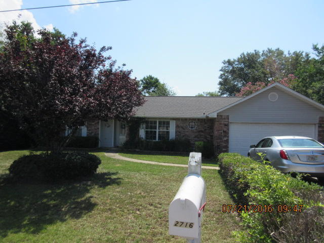 2716 Rambler Court Navarre, FL 32566 - Photo 1 of 1 a front view of house with yard and trees in the background