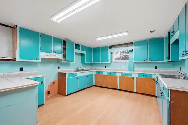a kitchen with stainless steel appliances granite countertop a sink cabinets and wooden floor