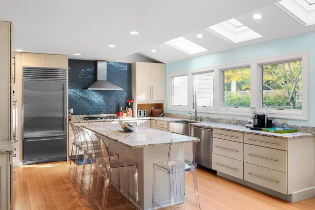 a kitchen with stainless steel appliances granite countertop a sink stove and refrigerator