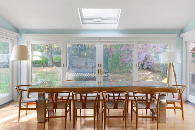 a view of a dining room with furniture large windows and wooden floor