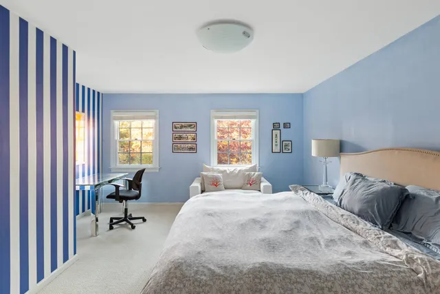 a bedroom with a bed and large windows