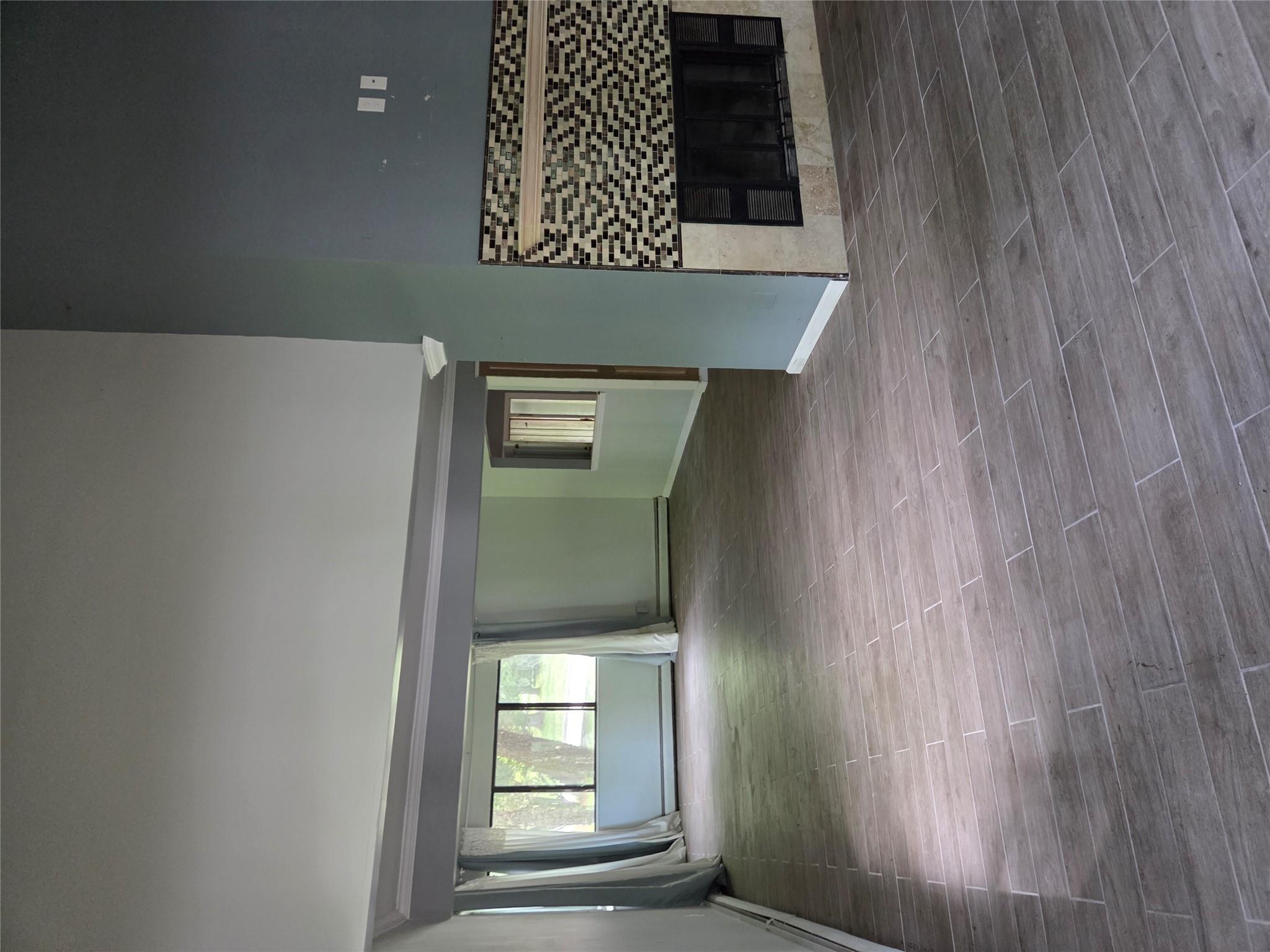 69 Mitchell Road Somers, NY 10589 - Photo 11 of 18 Unfurnished living room with a towering ceiling, a fireplace, and wood finished floors