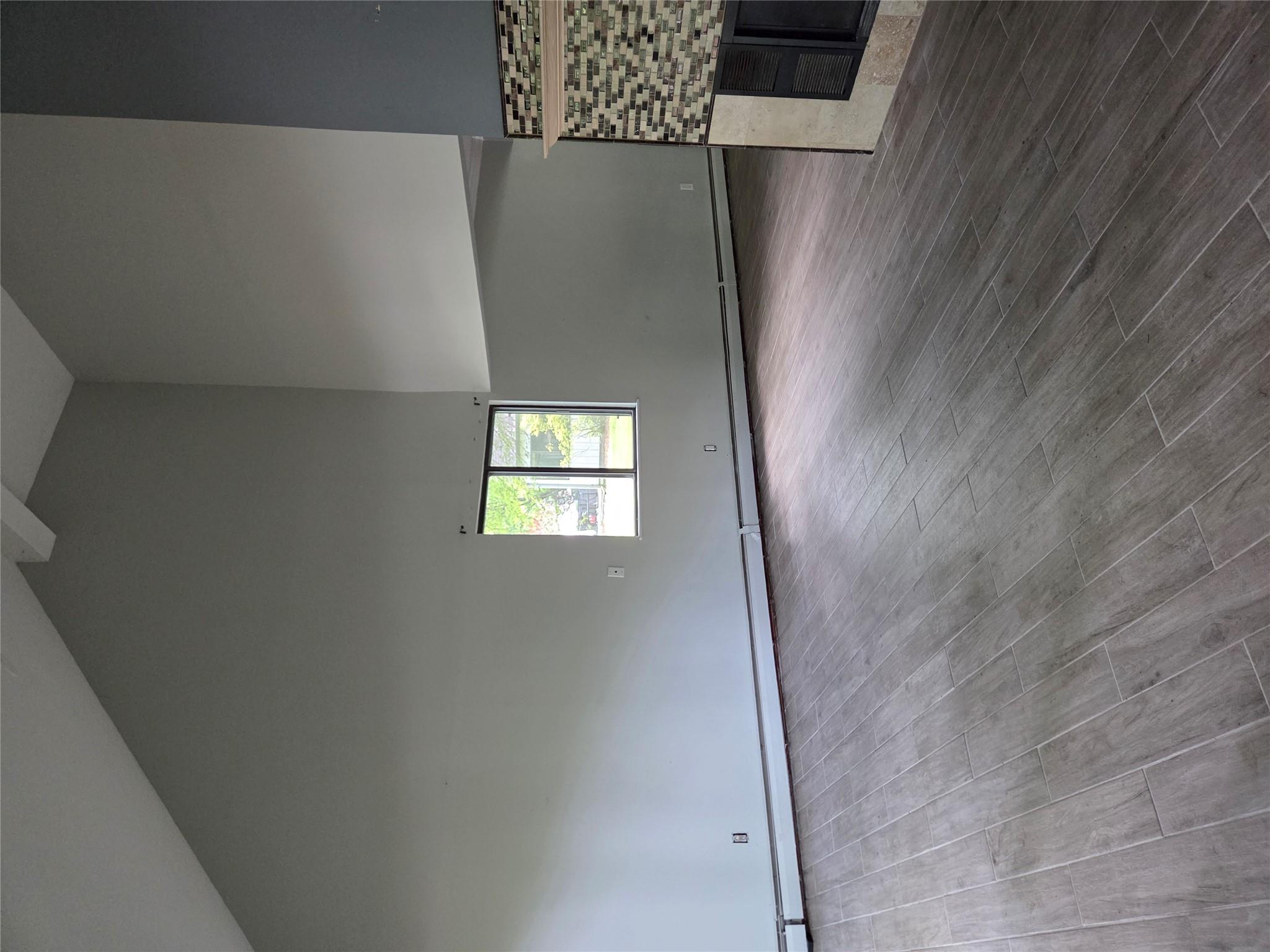 69 Mitchell Road Somers, NY 10589 - Photo 12 of 18 Unfurnished living room with high vaulted ceiling, a tiled fireplace, beamed ceiling, wood finished floors, and a baseboard heating unit