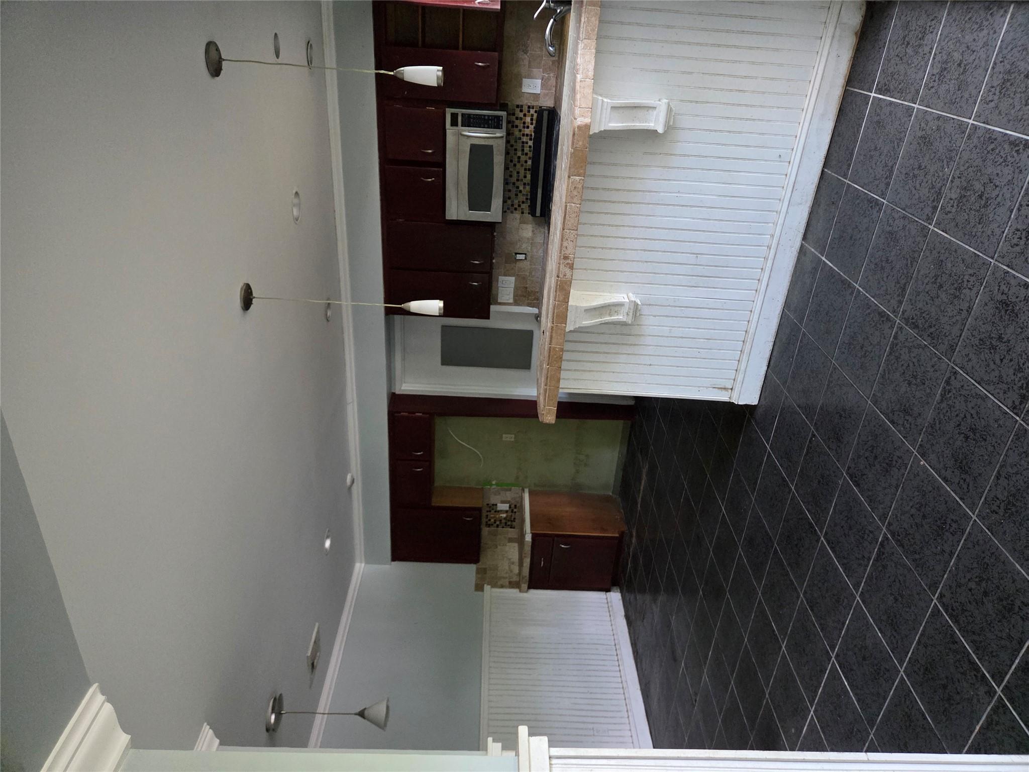 69 Mitchell Road Somers, NY 10589 - Photo 14 of 18 Kitchen with crown molding, dark tile patterned flooring, a wainscoted wall, decorative backsplash, and a breakfast bar area