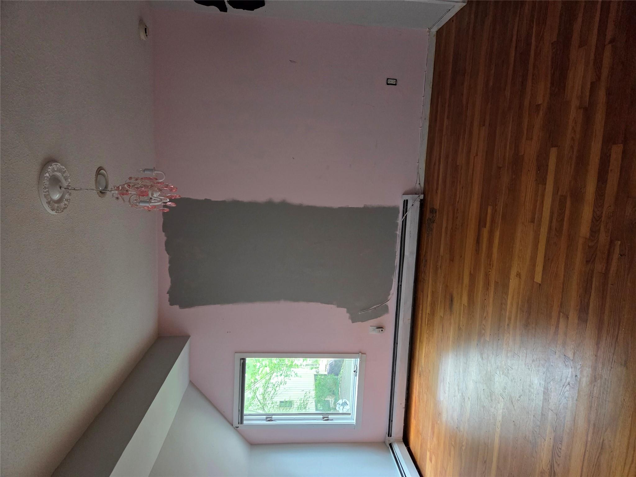 69 Mitchell Road Somers, NY 10589 - Photo 16 of 18 Spare room featuring wood finished floors, lofted ceiling, a textured ceiling, baseboard heating, and a chandelier