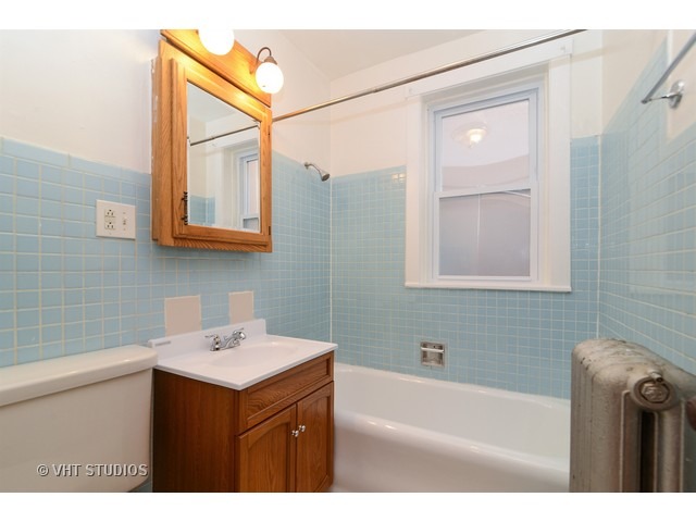 5110 West Roscoe Street Chicago, IL 60641 - Photo 8 of 10 a bathroom with a sink a bathtub and a shower