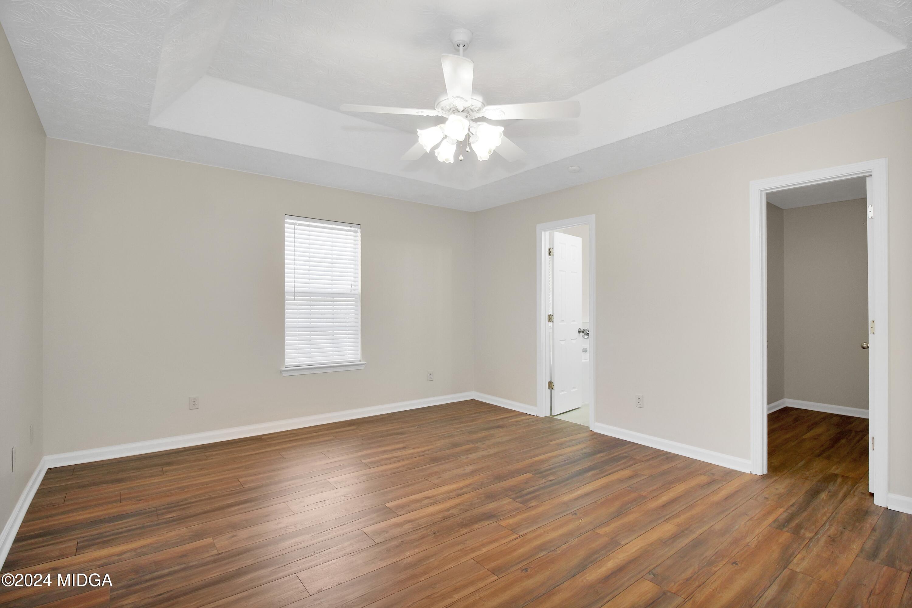 106 Meadow View Drive Jackson, GA 30233 - Photo 18 of 40 an empty room with wooden floor chandelier fan and windows