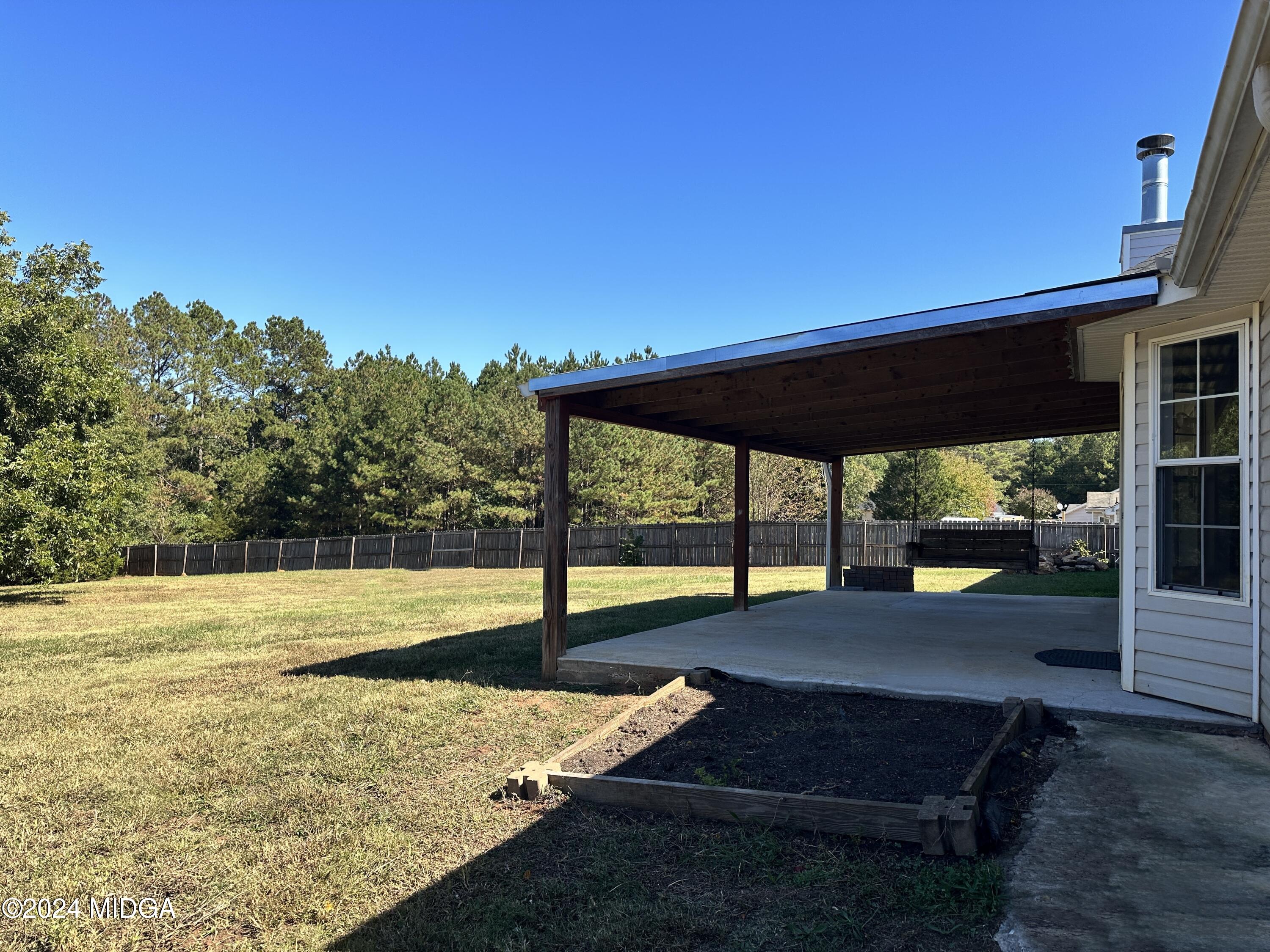 106 Meadow View Drive Jackson, GA 30233 - Photo 27 of 40 a view of a backyard with lawn chairs under an umbrella