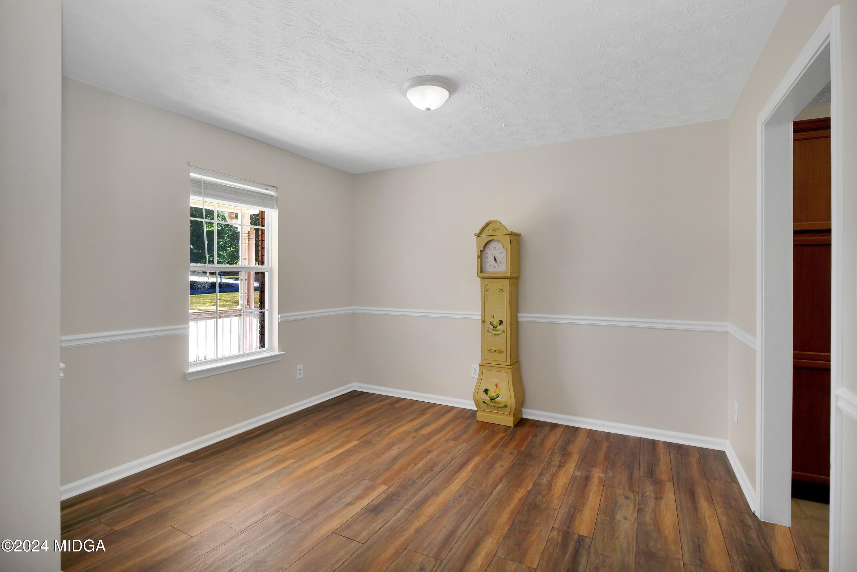 106 Meadow View Drive Jackson, GA 30233 - Photo 6 of 40 an empty room with wooden floor and windows