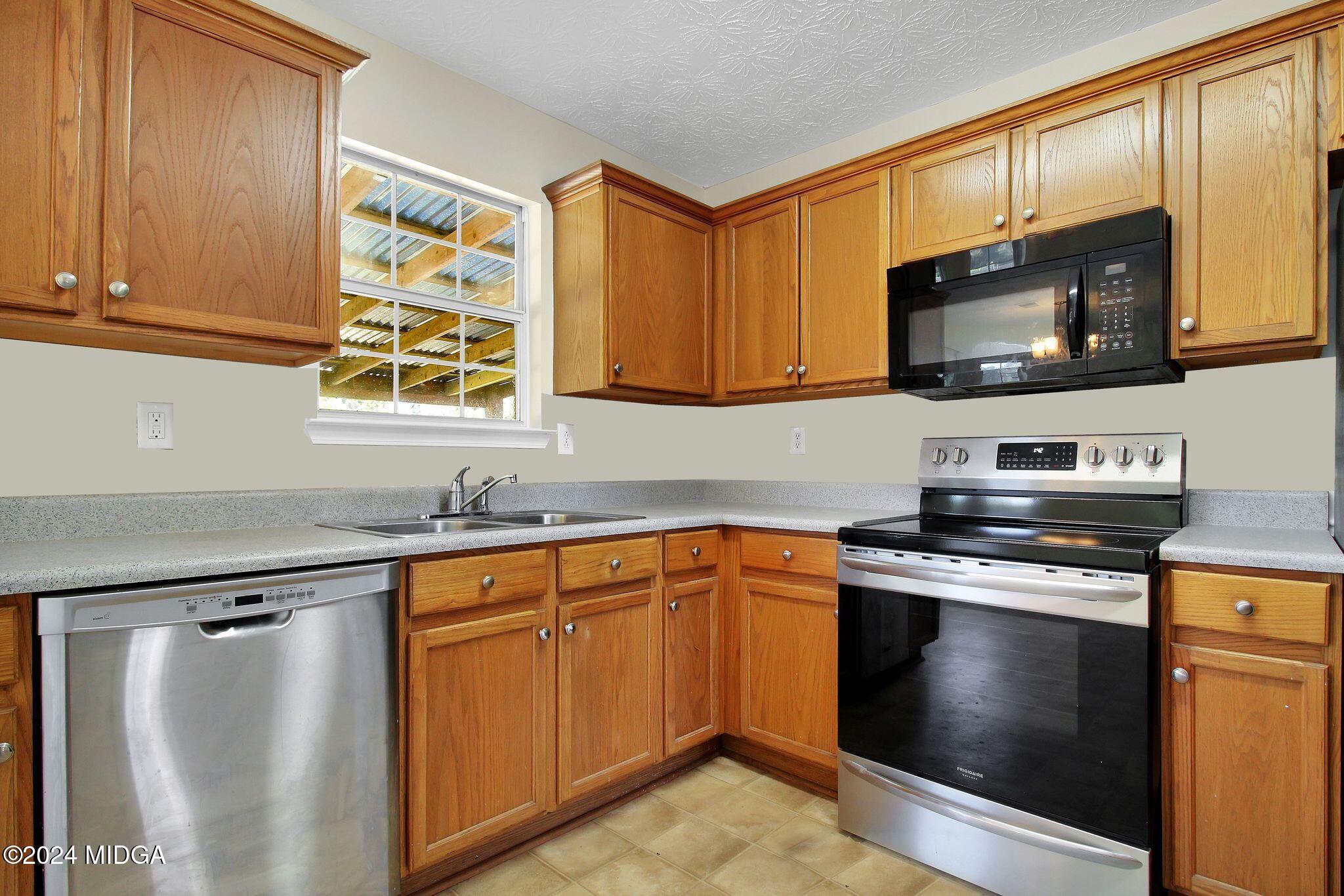 106 Meadow View Drive Jackson, GA 30233 - Photo 7 of 40 a kitchen with stainless steel appliances a stove a microwave and cabinets