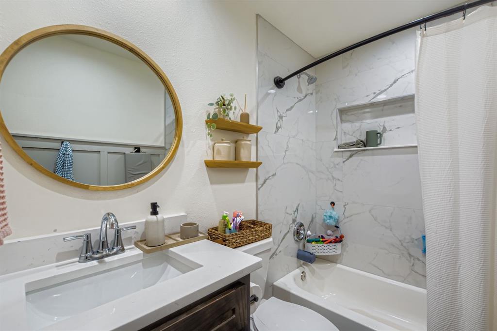 1601 Rindie Street Irving, TX 75060 - Photo 15 of 29 a bathroom with a sink mirror toilet and bathtub