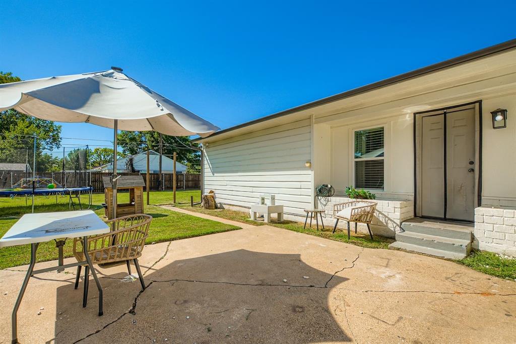 1601 Rindie Street Irving, TX 75060 - Photo 19 of 29 a view of a patio with a table and chairs under an umbrella