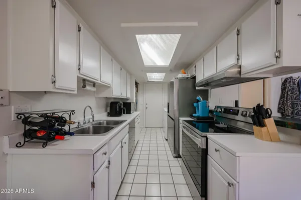a kitchen with a sink a refrigerator and cabinets