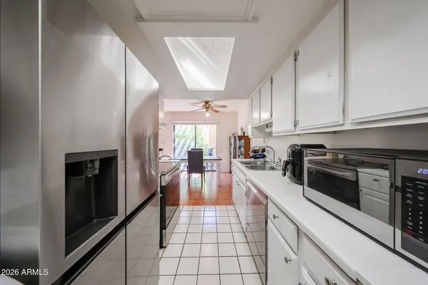 a kitchen with granite countertop a stove a sink and a refrigerator