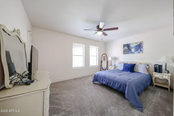 a living room with a bed furniture flat screen tv and a window