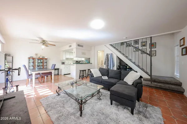 a living room with furniture and a dining table with wooden floor