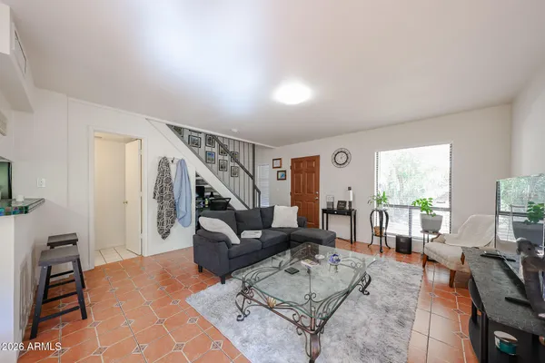 a living room with furniture rug and a window