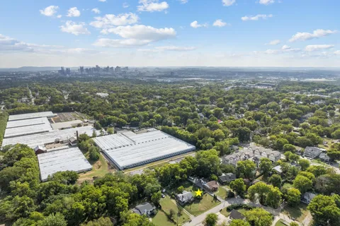 an aerial view of a residential apartment building with a yard and mountain view in back