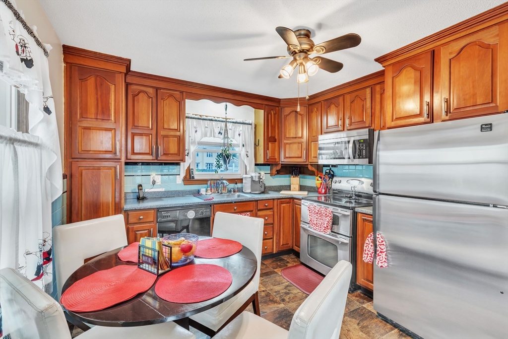 513 Springfield Street Chicopee, MA 01013 - Photo 13 of 38 a kitchen with stainless steel appliances granite countertop a stove a sink dishwasher and a dining table with cabinets