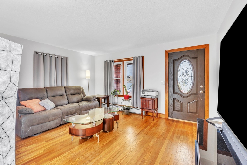 513 Springfield Street Chicopee, MA 01013 - Photo 7 of 38 a living room with furniture a large window and wooden floor