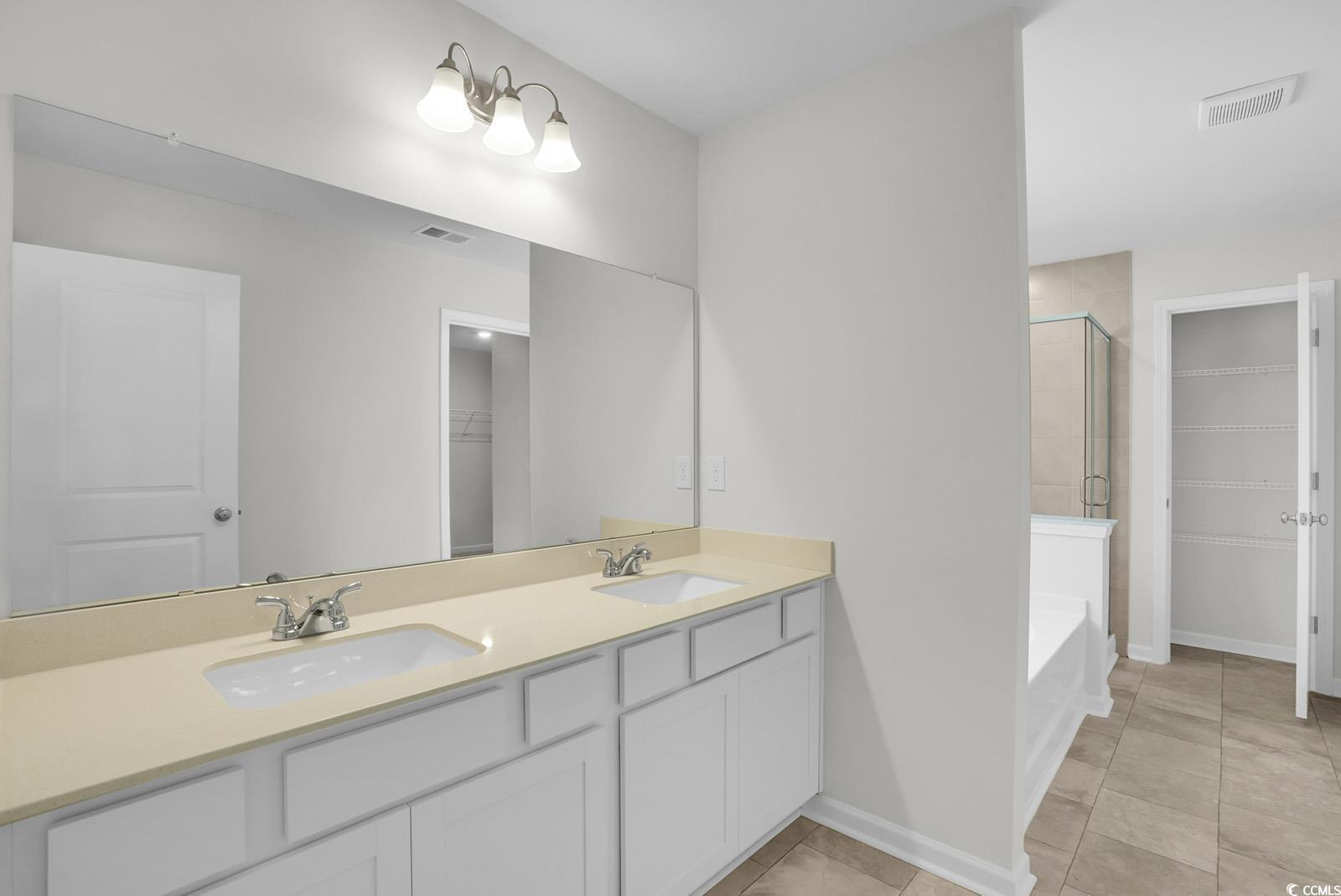 1113 Hainer Place Drive Conway, SC 29526 - Photo 13 of 28 Full bathroom with a walk in closet, a stall shower, double vanity, and light tile patterned floors