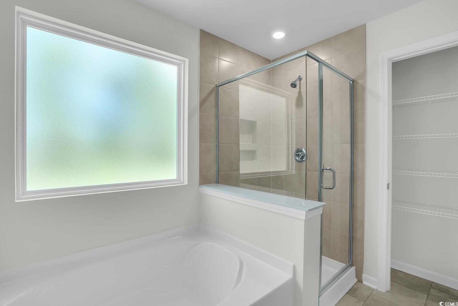 1113 Hainer Place Drive Conway, SC 29526 - Photo 15 of 28 Bathroom with a garden tub, a stall shower, tile patterned floors, and a spacious closet