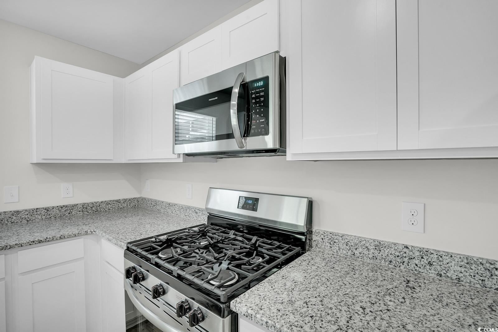 1113 Hainer Place Drive Conway, SC 29526 - Photo 5 of 28 Kitchen with appliances with stainless steel finishes, white cabinets, and light stone counters