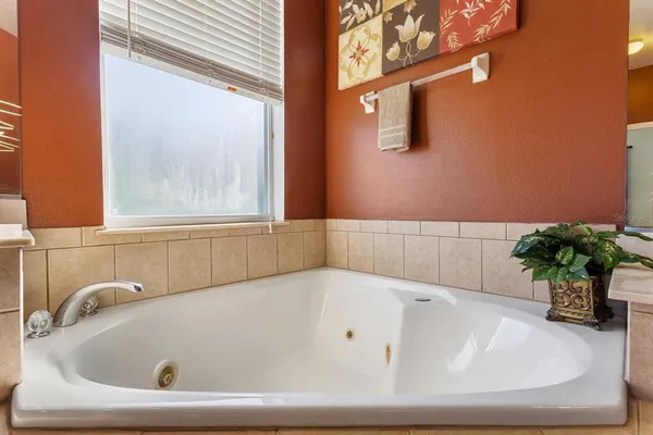 a bathroom with a tub sink and mirror