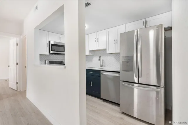 a kitchen with stainless steel appliances a stove microwave and sink
