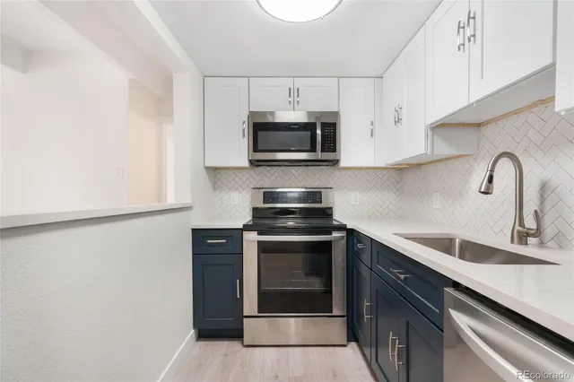 a kitchen with stainless steel appliances a refrigerator sink and microwave
