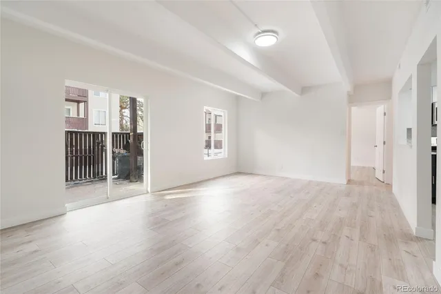 a view of empty room with wooden floor