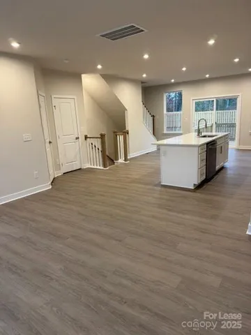 a view of kitchen with kitchen island granite countertop a stove top oven a sink and a granite counter top