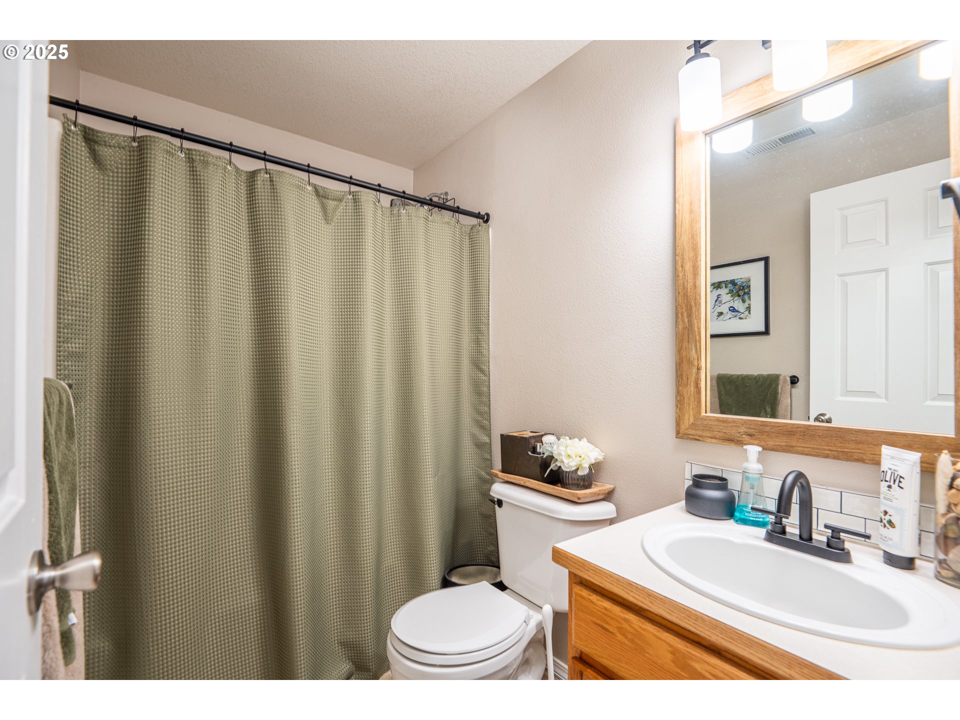 2002 South 60th Street Springfield, OR 97478 - Photo 26 of 47 a bathroom with a sink a toilet a mirror and shower curtain