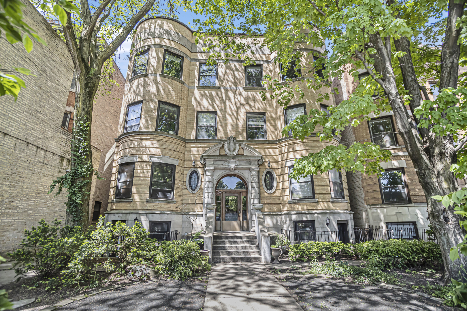 4030 North Sheridan Road, Unit 1R Chicago, IL 60613 - Photo 2 of 16 front view of a brick house with a large tree