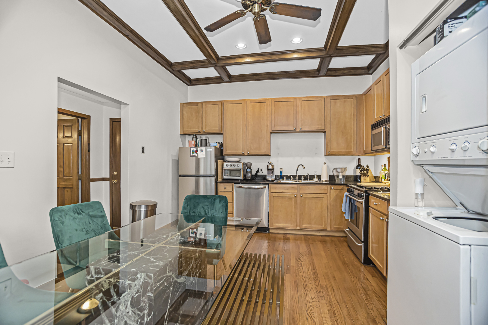 4030 North Sheridan Road, Unit 1R Chicago, IL 60613 - Photo 7 of 16 a kitchen with stainless steel appliances granite countertop a refrigerator a stove top oven a sink dishwasher and white cabinets with wooden floor