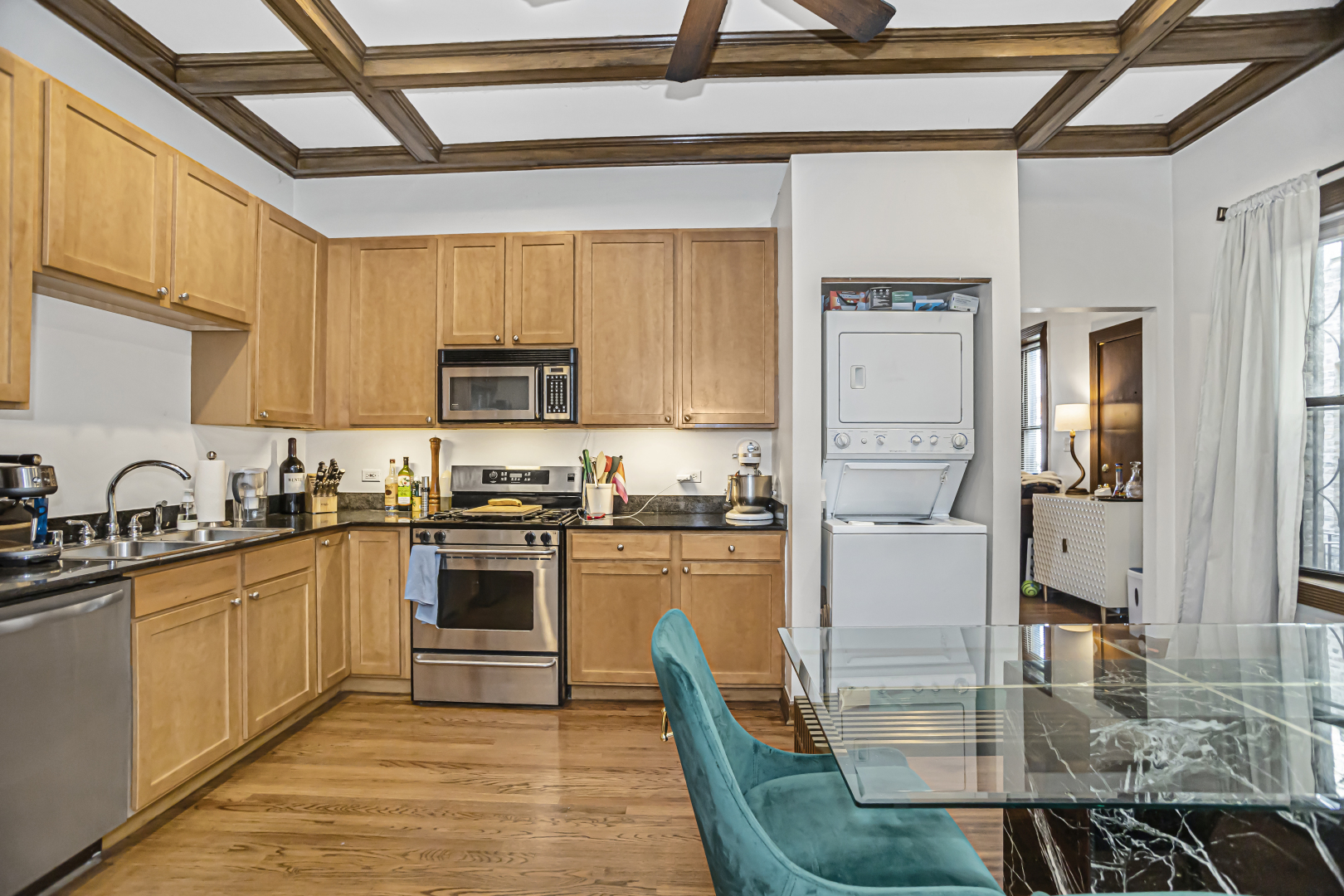 4030 North Sheridan Road, Unit 1R Chicago, IL 60613 - Photo 9 of 16 a kitchen with stainless steel appliances granite countertop a stove top oven a sink and dishwasher