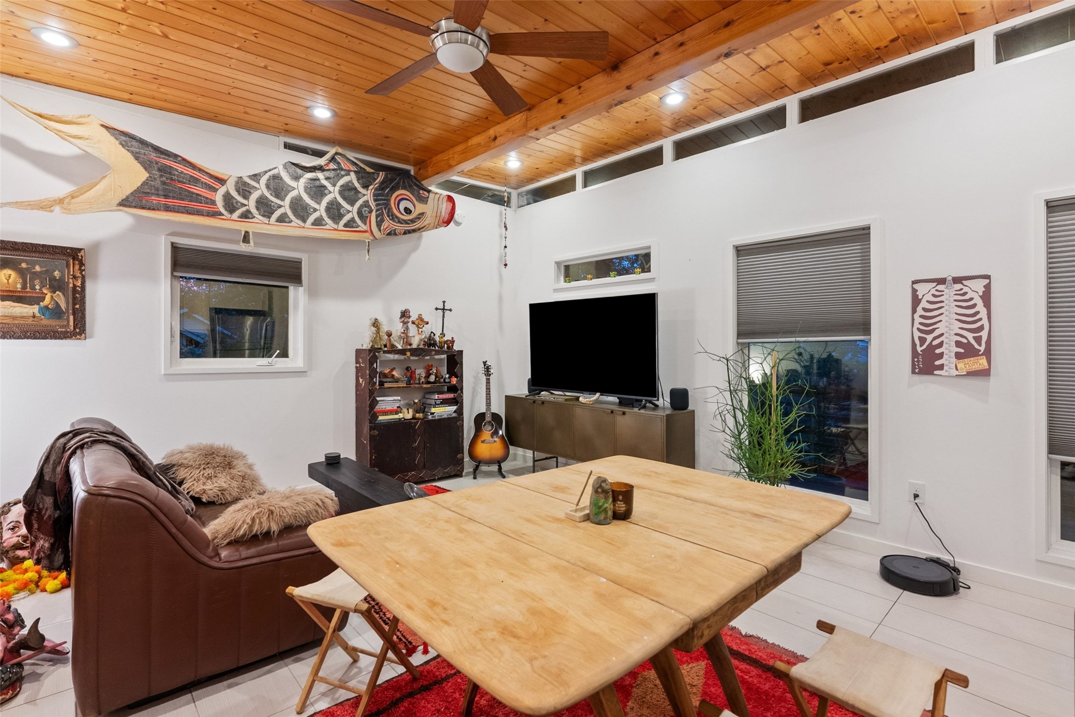 412 West Croslin Street Austin, TX 78752 - Photo 23 of 36 A living space offers high ceilings, exposed wood beams, and ample natural light through well-placed windows.