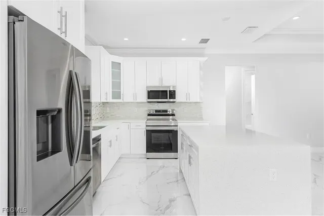 a view of a kitchen with a stove cabinets a ceiling fan and a window