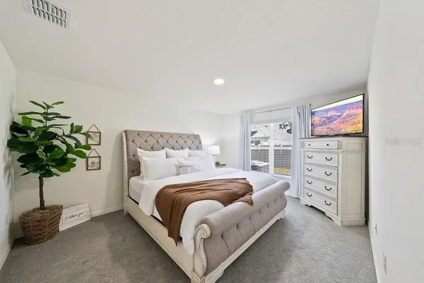 a bedroom with a bed and a potted plant