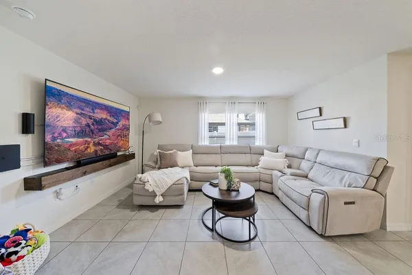 a living room with furniture a rug and a flat screen tv