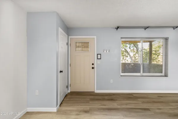 an empty room with wooden floor and windows