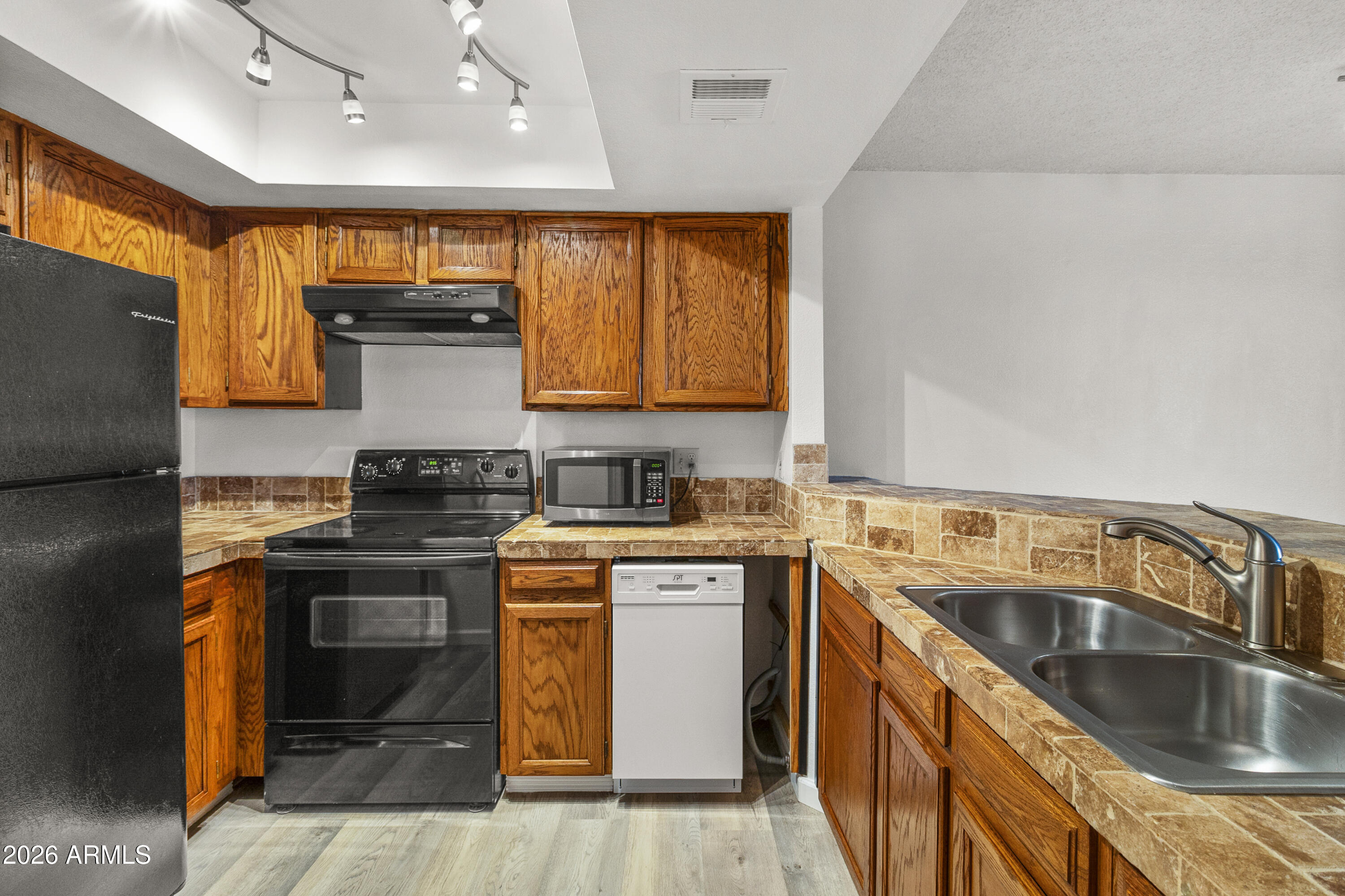 1645 West Baseline Road, Unit 2110 Mesa, AZ 85202 - Photo 6 of 17 a kitchen with stainless steel appliances granite countertop a sink stove and refrigerator