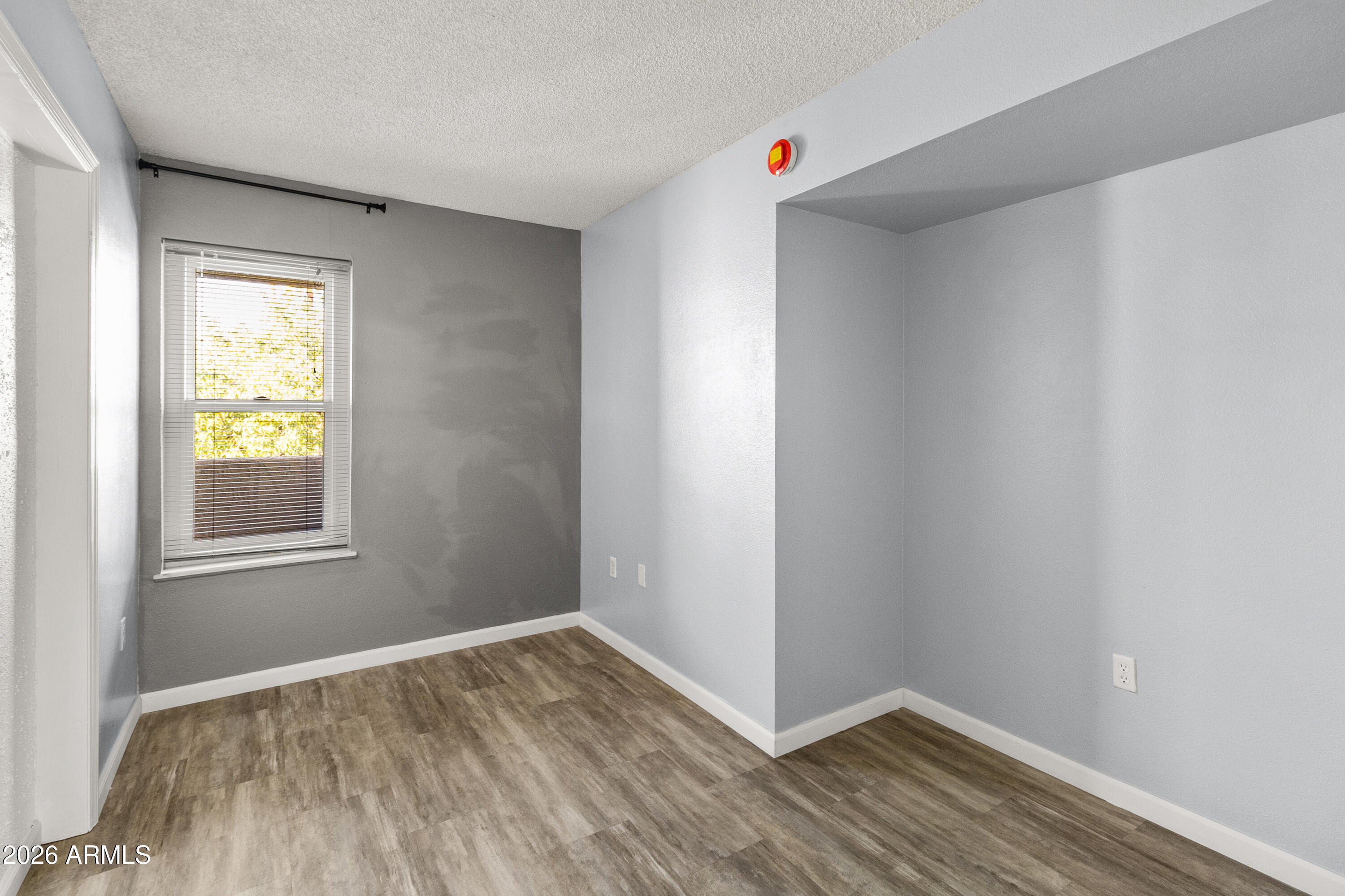 1645 West Baseline Road, Unit 2110 Mesa, AZ 85202 - Photo 9 of 17 a view of an empty room with wooden floor and a window