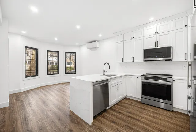a large kitchen with stainless steel appliances granite countertop a stove and a sink