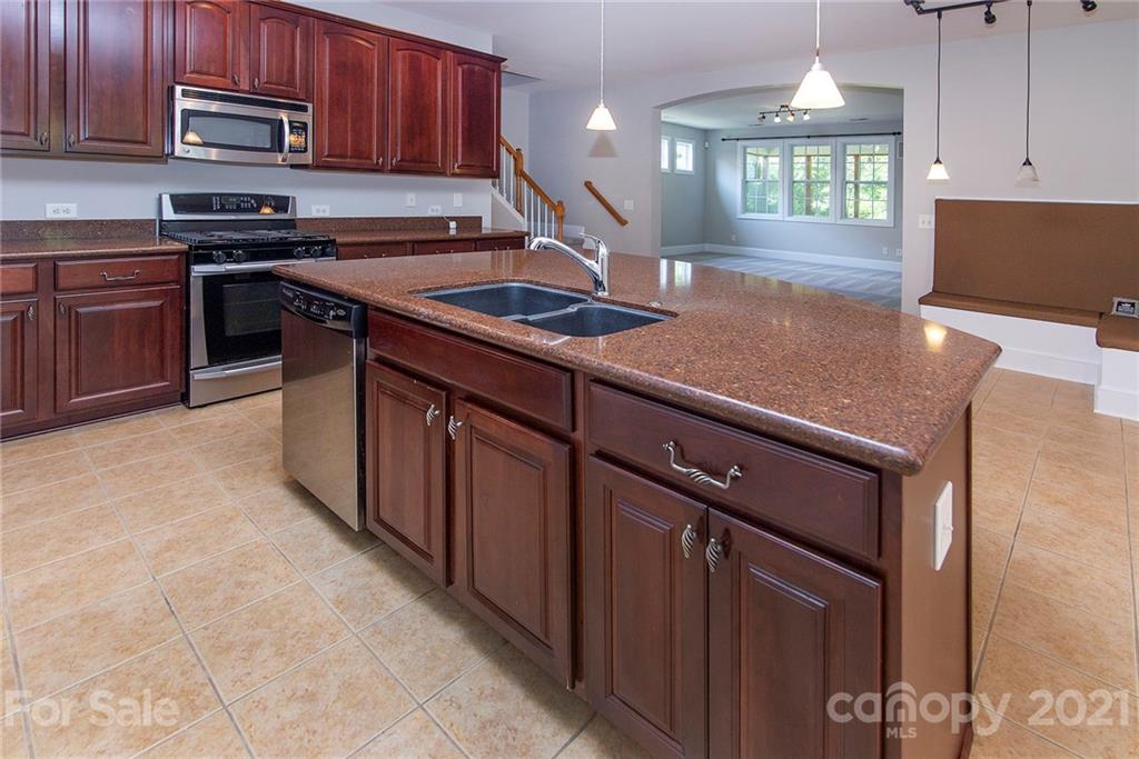10617 Round Rock Road Charlotte, NC 28277 - Photo 6 of 28 a kitchen with stainless steel appliances granite countertop a stove a sink and a microwave