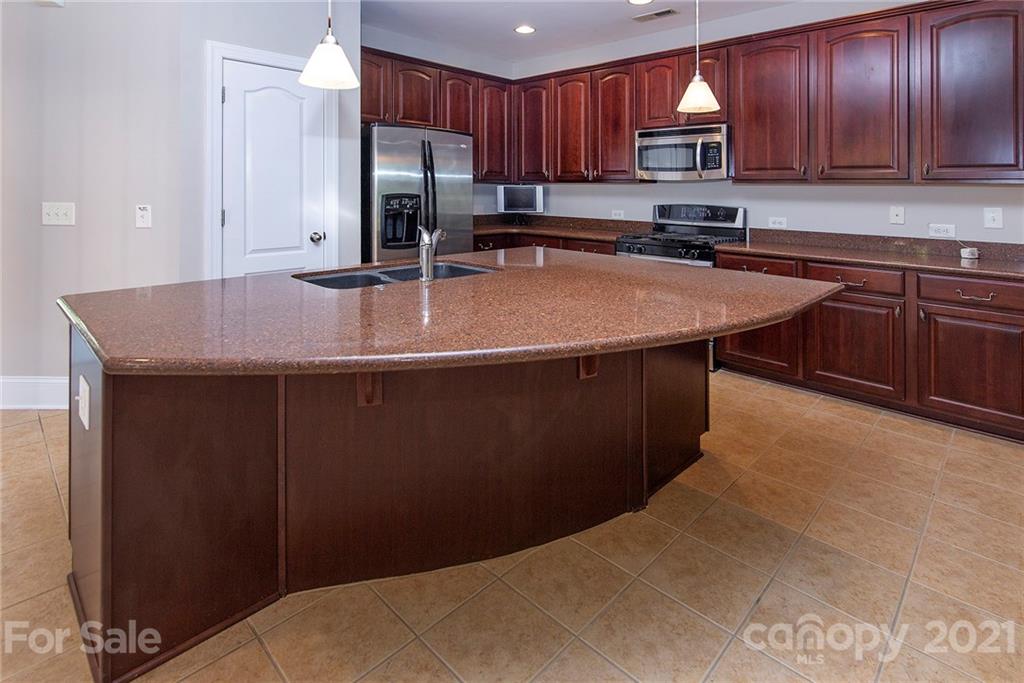 10617 Round Rock Road Charlotte, NC 28277 - Photo 7 of 28 a kitchen with stainless steel appliances a sink a microwave a refrigerator and cabinets