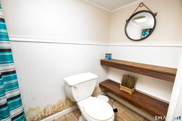 a bathroom with a toilet a sink and a mirror