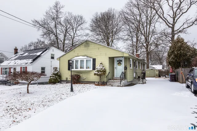 a view of a house with a yard covered in snow